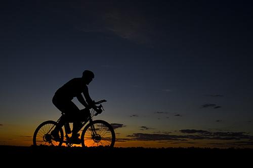 Across the US by Bicycle Person riding bicycle at sunset