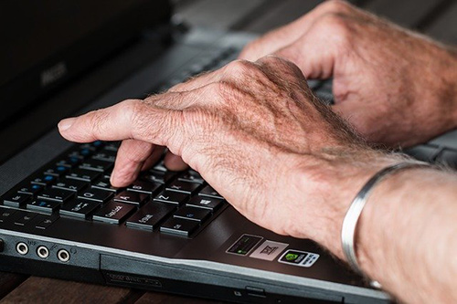 Older man using laptop to write