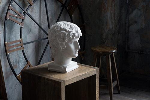 Philosopher statue with clock behind