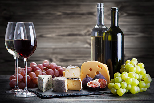 Wine and Cheese Bottles of white and red wine, grapes, and assorted cheeses