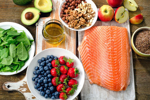 chronic-nutrition Image of spinach, fruits, and salmon on a tabletop