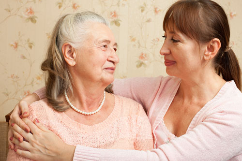 Older adult woman and a younger adult woman hugging