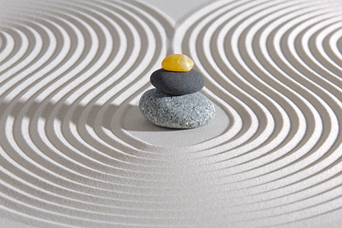Japanese zen garden with stone in textured sand Stones stacked in a Zen Garden