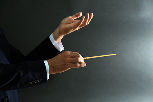 Music conductor hands with baton on black background