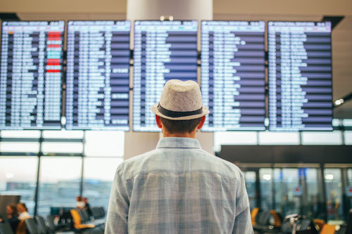 Man looking at list of flights in an airport