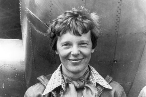 Amelia Earhart in front ofher plane
