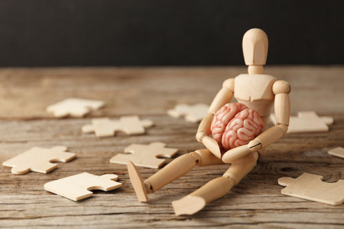 Wooden figure of a man holding a brain