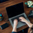 Female photographer working on photos on laptop and camera.