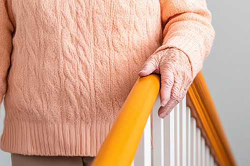 MAn holding a handrail as he goes down stairs